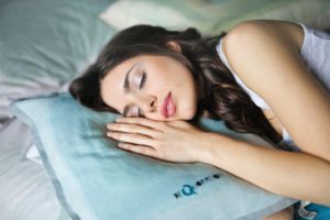 a woman sleeping on a blue pillow