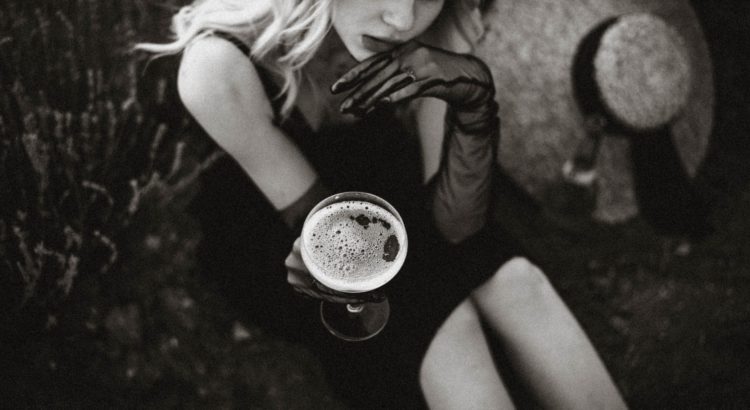 blonde woman in black and white photo with drink