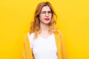 blonde model with red lipstick and glasses in front of yellow background