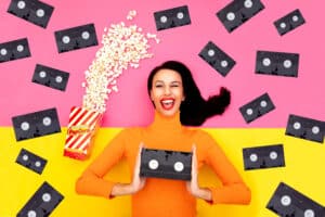 woman holding a vhs tape and others flying around her with popcorn 