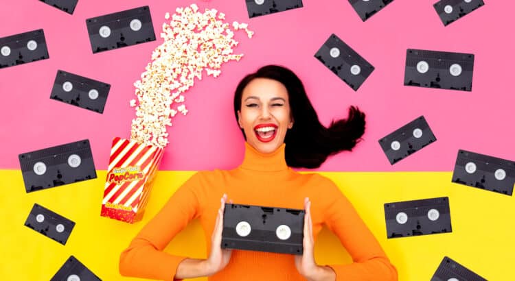 woman holding a vhs tape and others flying around her with popcorn 