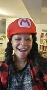 photo of the author Sylvie Soulet wearing a Mario hat and her hair in pigtails